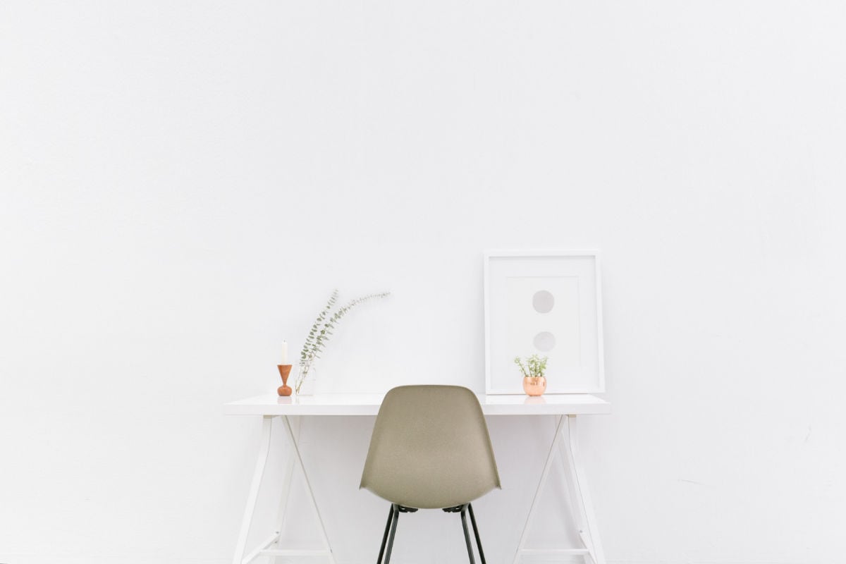 A white wooden table near a brown chair.